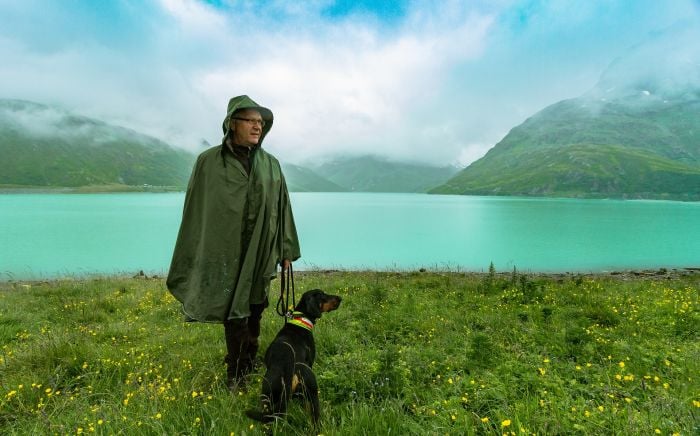 Mężczyzna z psem na brzegu jeziora.