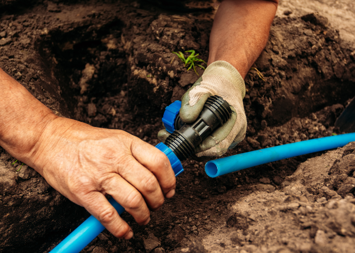 Montowanie systemu nawadniającego ogród.